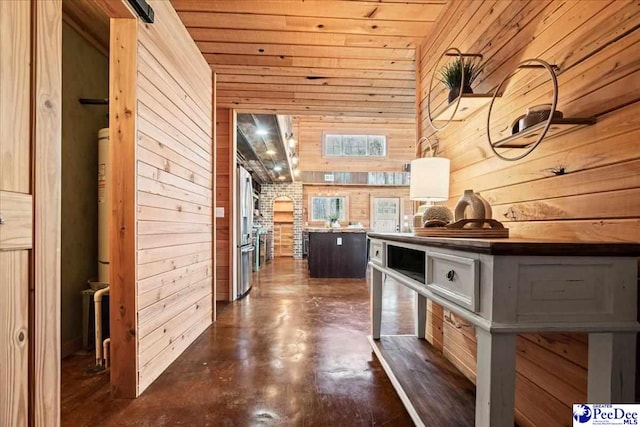 corridor featuring wooden ceiling, concrete floors, and wooden walls