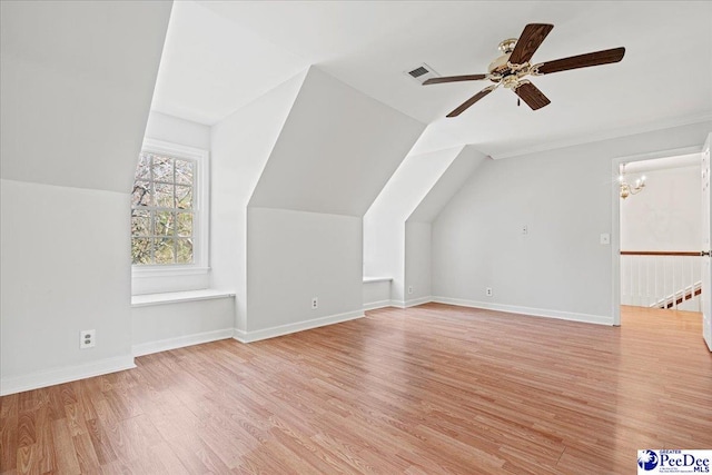 additional living space featuring baseboards, visible vents, vaulted ceiling, and light wood finished floors