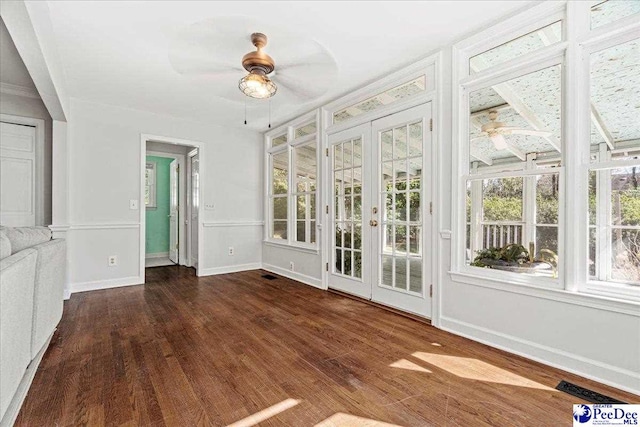 unfurnished sunroom featuring ceiling fan