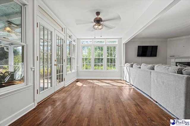 unfurnished sunroom featuring ceiling fan