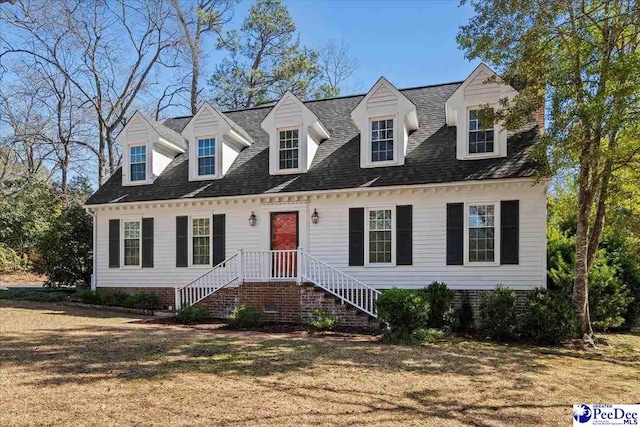 cape cod house featuring a front yard and roof with shingles