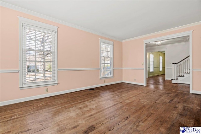 spare room featuring visible vents, ornamental molding, wood finished floors, baseboards, and stairs