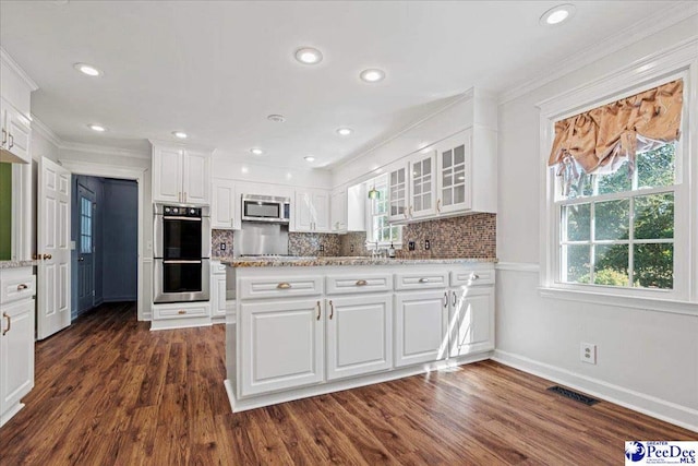 kitchen featuring stainless steel appliances, light stone counters, glass insert cabinets, and white cabinetry