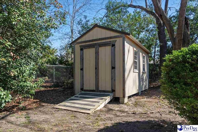 view of shed featuring fence