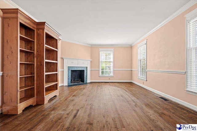 unfurnished living room featuring baseboards, visible vents, dark wood-style floors, crown molding, and a high end fireplace