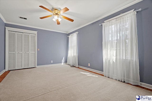 unfurnished bedroom featuring ceiling fan, ornamental molding, visible vents, and baseboards