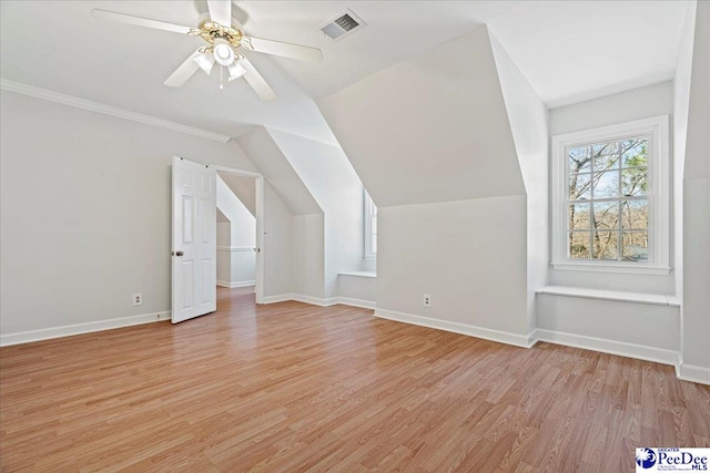 additional living space featuring visible vents, vaulted ceiling, light wood-style flooring, and baseboards