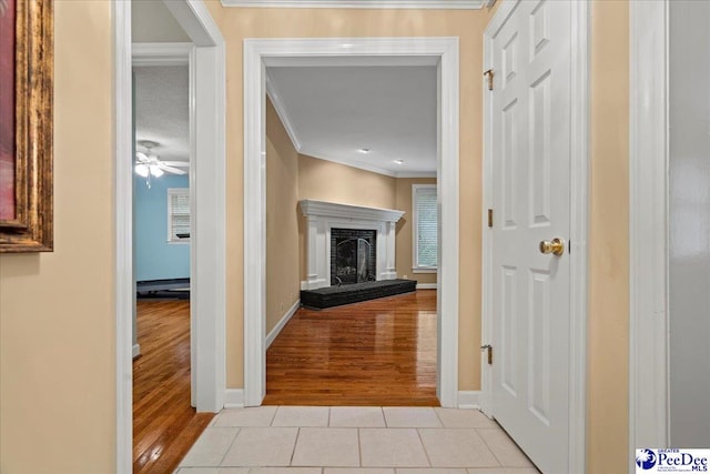 corridor with crown molding and light tile patterned floors