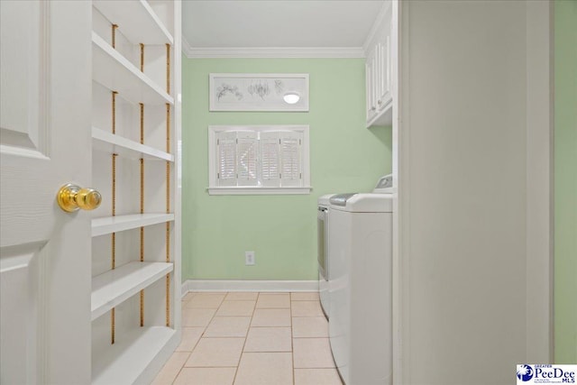 laundry area featuring cabinets, ornamental molding, light tile patterned floors, and washer and clothes dryer