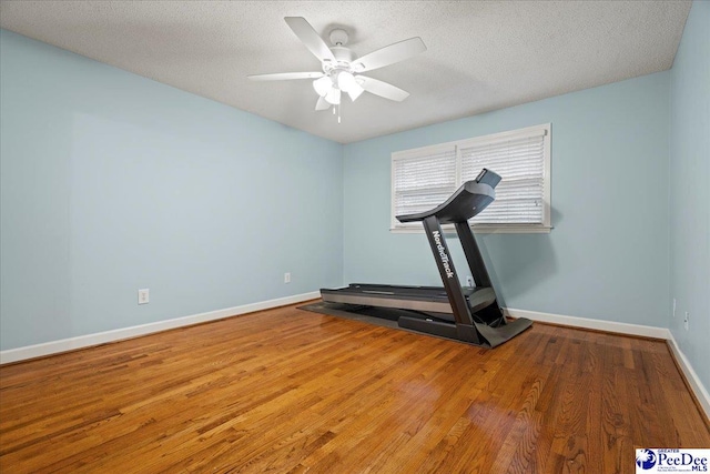 exercise area with ceiling fan, wood-type flooring, and a textured ceiling