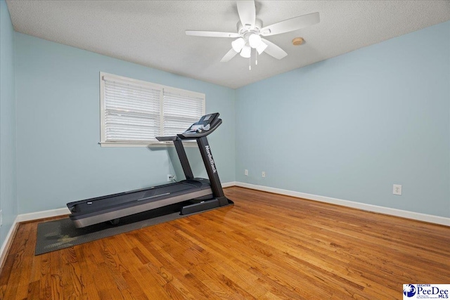 workout area with ceiling fan, a textured ceiling, and light wood-type flooring