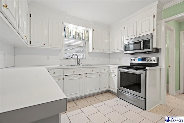 kitchen with sink, crown molding, appliances with stainless steel finishes, white cabinets, and light tile patterned flooring