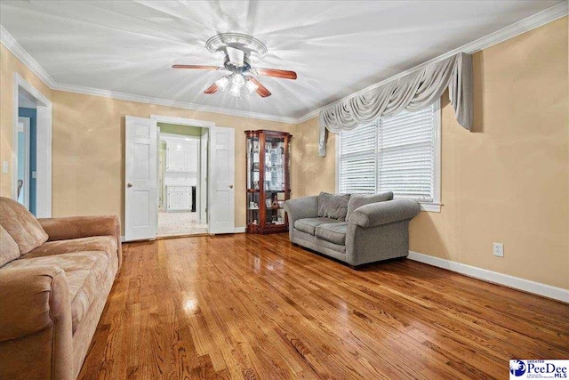 living room with hardwood / wood-style floors, crown molding, and ceiling fan