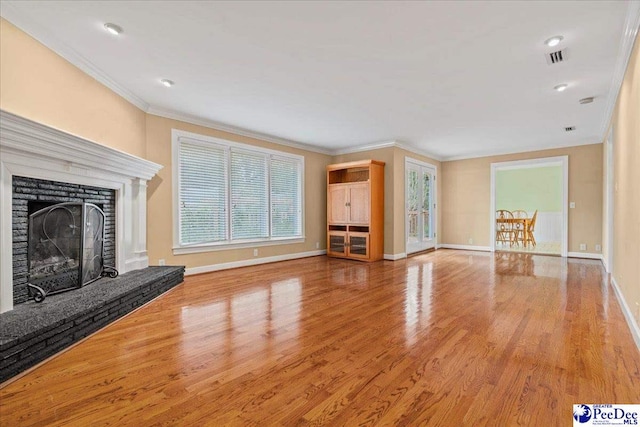 unfurnished living room with crown molding, a fireplace, and light hardwood / wood-style floors