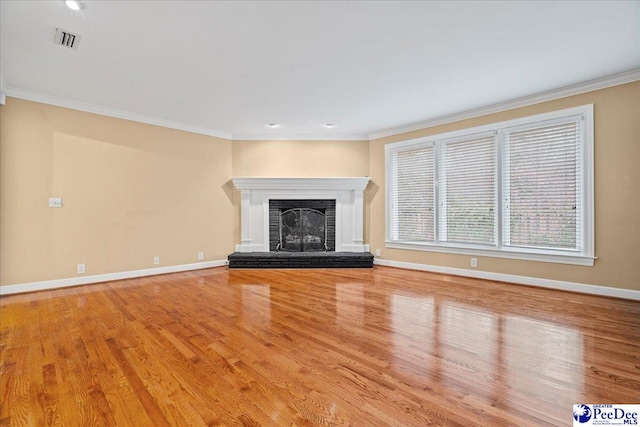 unfurnished living room featuring ornamental molding, a brick fireplace, and light hardwood / wood-style flooring