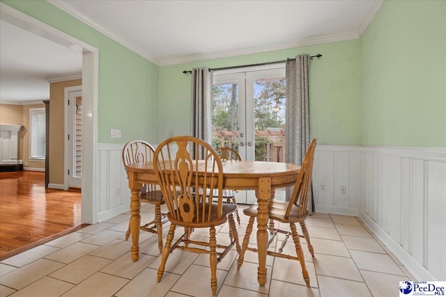 dining room featuring crown molding, light tile patterned flooring, and french doors