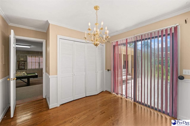 1110 Dunvegan Rd, Florence, SC 29501 - unfurnished dining area with wood finished floors, a chandelier, ornamental molding, and a wainscoted wall