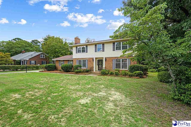 1110 Dunvegan Rd, Florence, SC 29501 - colonial-style house featuring a chimney, brick siding, and a front yard