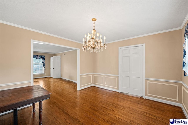 1110 Dunvegan Rd, Florence, SC 29501 - unfurnished dining area featuring a chandelier, wood finished floors, crown molding, wainscoting, and a decorative wall