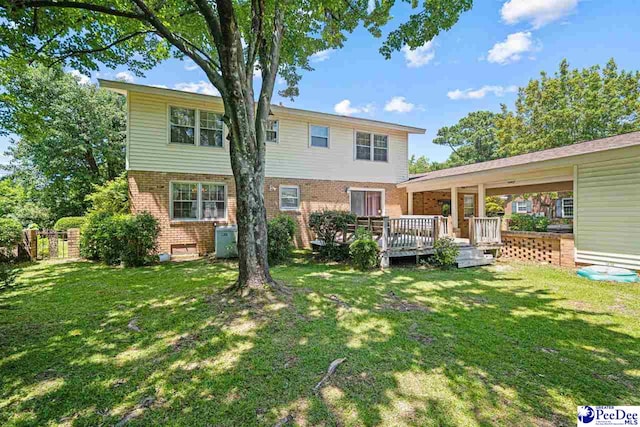 1110 Dunvegan Rd, Florence, SC 29501 - back of property featuring brick siding, a deck, and a lawn