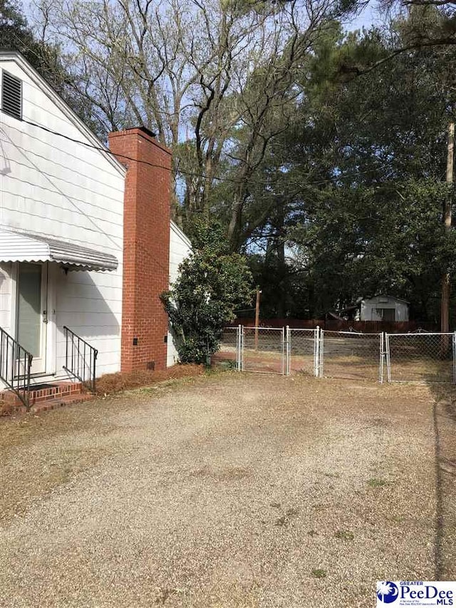 view of yard featuring entry steps, a gate, and fence