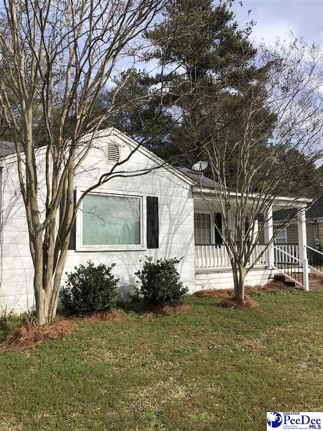 view of property exterior with covered porch and a yard