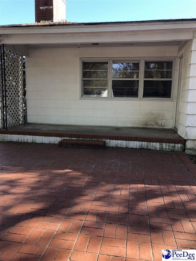 view of home's exterior featuring a patio area and a chimney