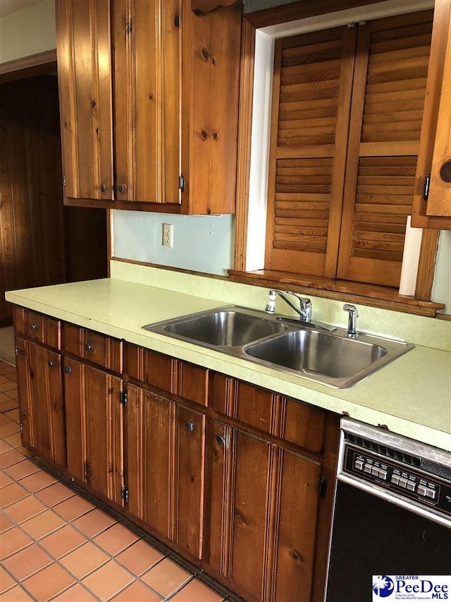 kitchen featuring black dishwasher, light countertops, and a sink