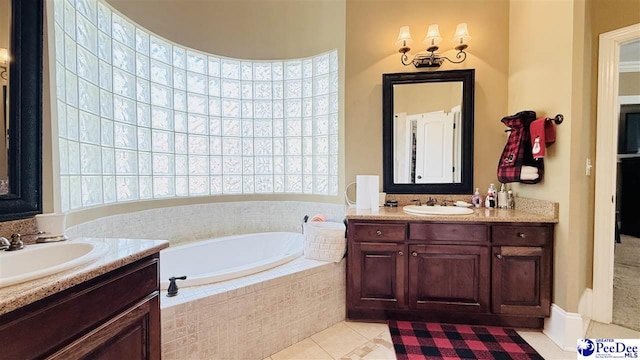 bathroom with tile patterned floors, vanity, and tiled bath