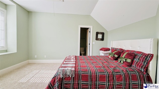bedroom featuring carpet, lofted ceiling, and ensuite bath