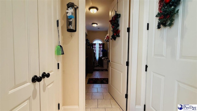hall with light tile patterned floors