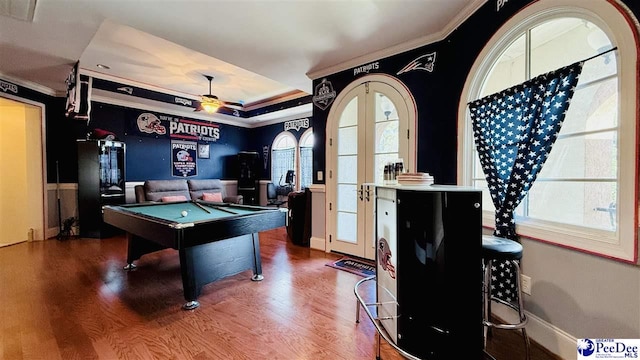 playroom featuring french doors, billiards, ornamental molding, a tray ceiling, and hardwood / wood-style floors