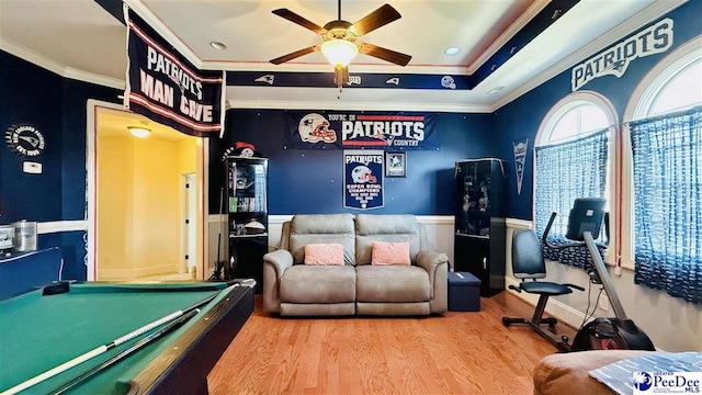 rec room with hardwood / wood-style floors, billiards, ornamental molding, ceiling fan, and a raised ceiling