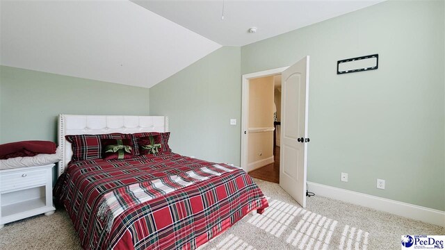 carpeted bedroom with lofted ceiling