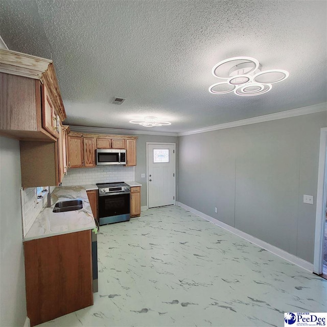 kitchen with marble finish floor, visible vents, appliances with stainless steel finishes, ornamental molding, and a sink