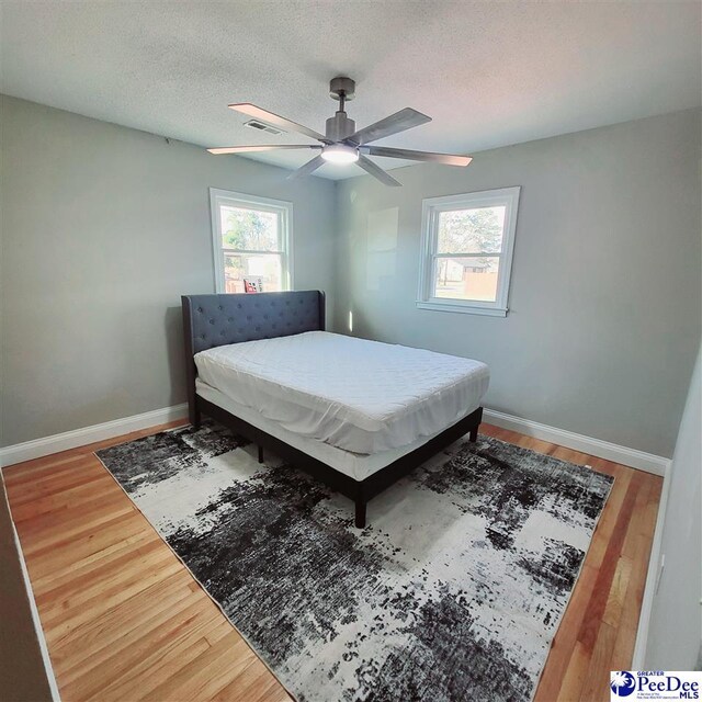 139 Wingate Ave, Florence, SC 29506 - bedroom featuring multiple windows, a textured ceiling, baseboards, and wood finished floors