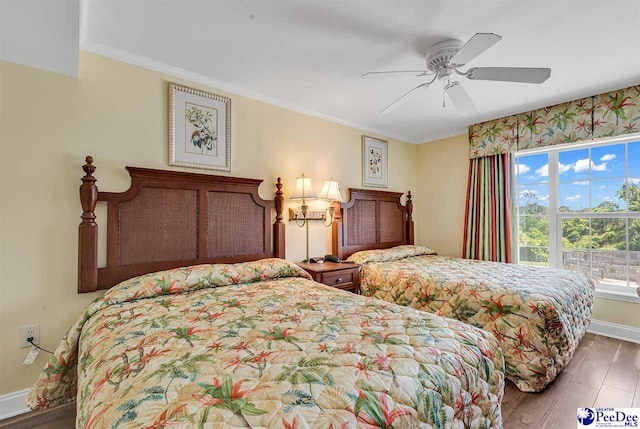 bedroom featuring baseboards, a ceiling fan, crown molding, and wood finished floors