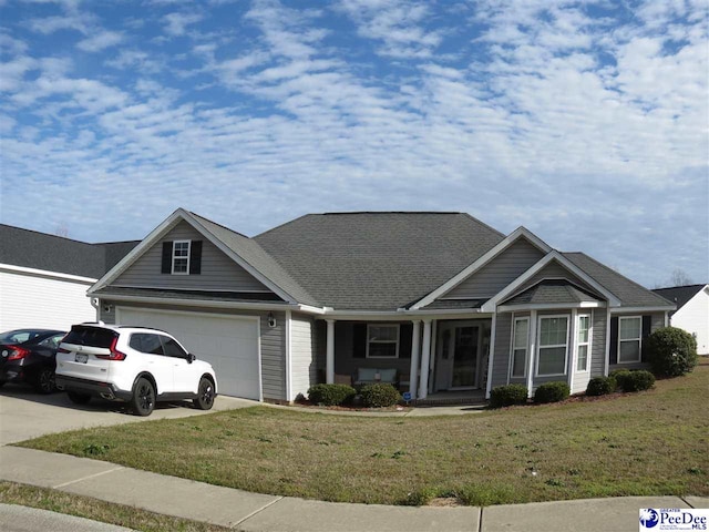 view of front of house featuring a front lawn, an attached garage, driveway, and a shingled roof