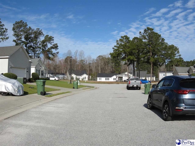 view of road featuring sidewalks, a residential view, and curbs