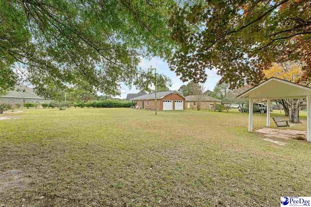 view of yard featuring a garage and a gazebo