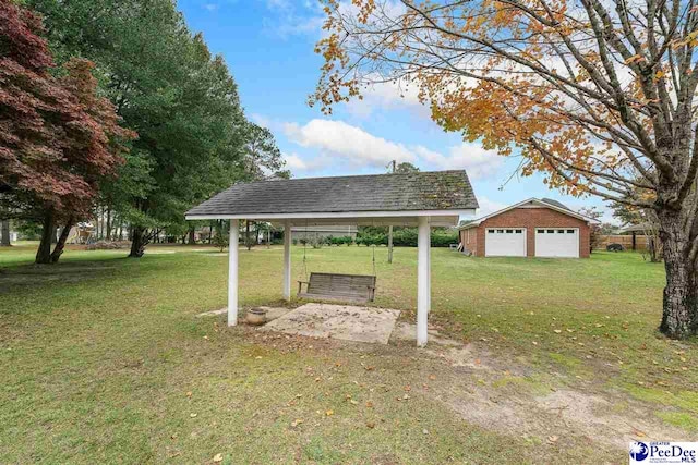 view of yard with a garage, an outdoor structure, and a carport