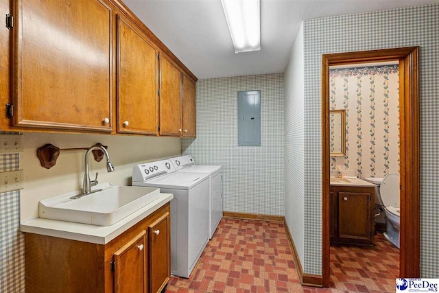 laundry area featuring sink, electric panel, cabinets, and washing machine and clothes dryer