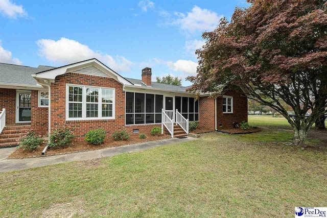 view of front of home with a sunroom and a front lawn