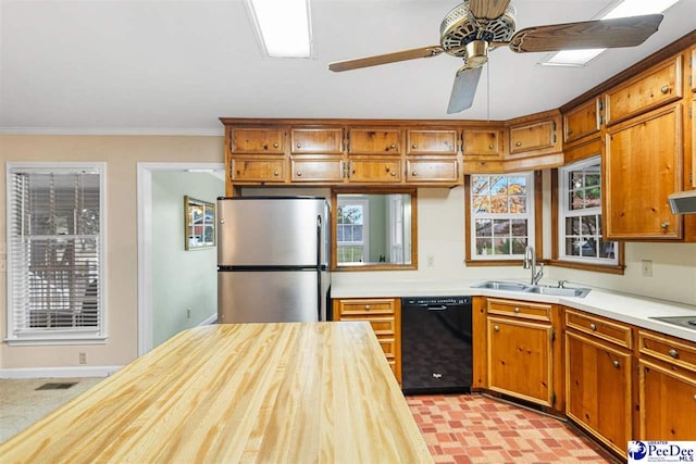 kitchen featuring sink, stainless steel refrigerator, ornamental molding, black dishwasher, and ceiling fan