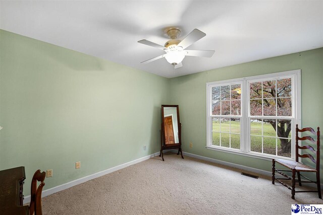 unfurnished room featuring ceiling fan, plenty of natural light, and carpet flooring