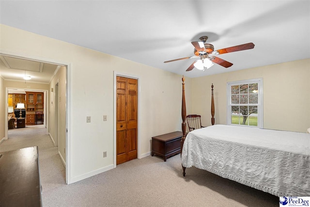 carpeted bedroom with ceiling fan and a closet