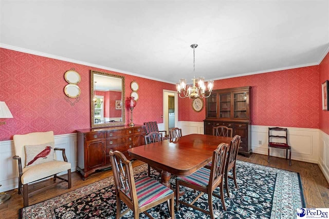 dining room with crown molding, washer / dryer, an inviting chandelier, and dark hardwood / wood-style flooring