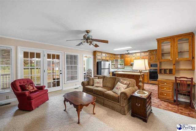 living room with crown molding, ceiling fan, and light carpet