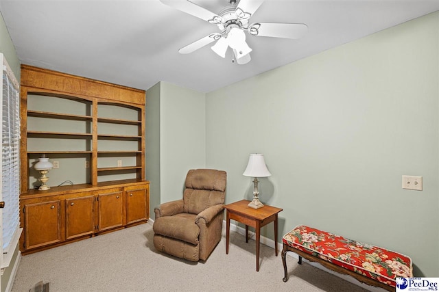 living area with light colored carpet and ceiling fan