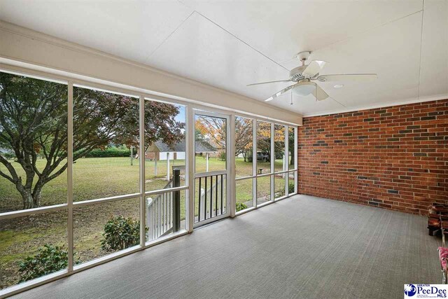 unfurnished sunroom featuring ceiling fan